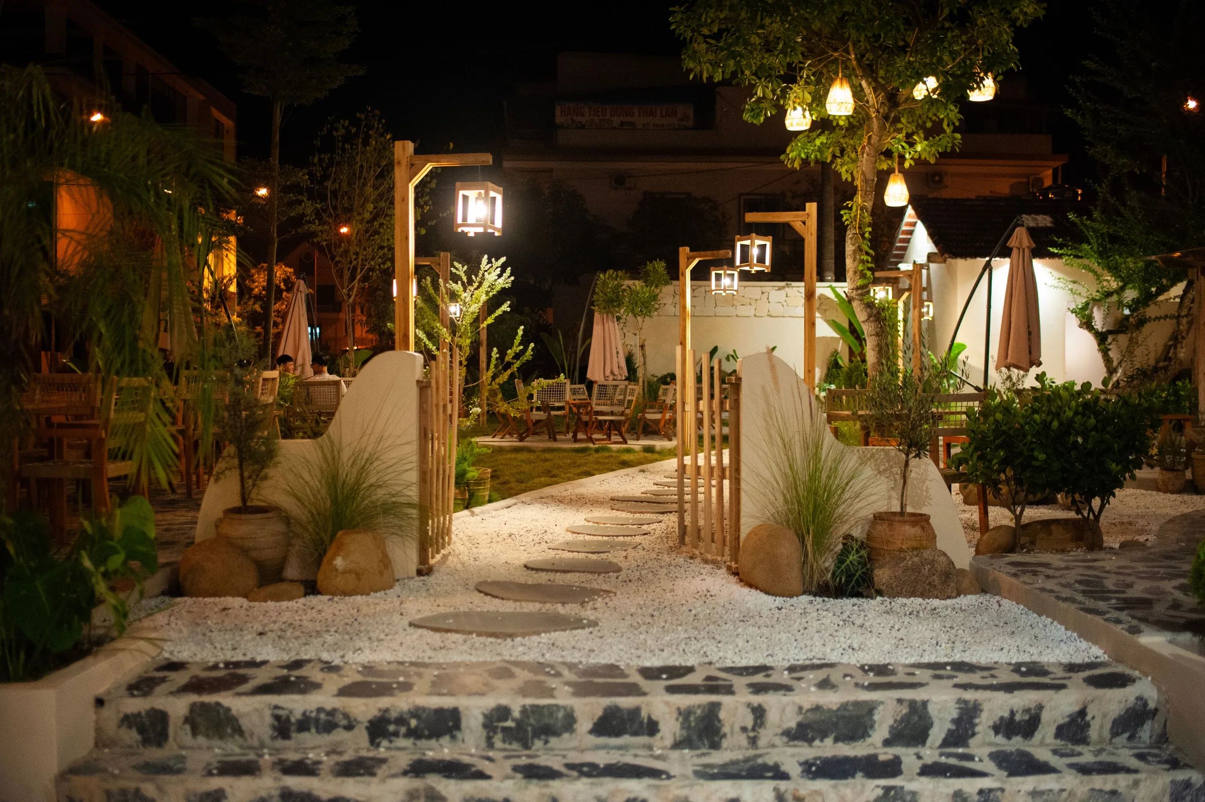Garden dining path illuminated by warm lanterns at night
